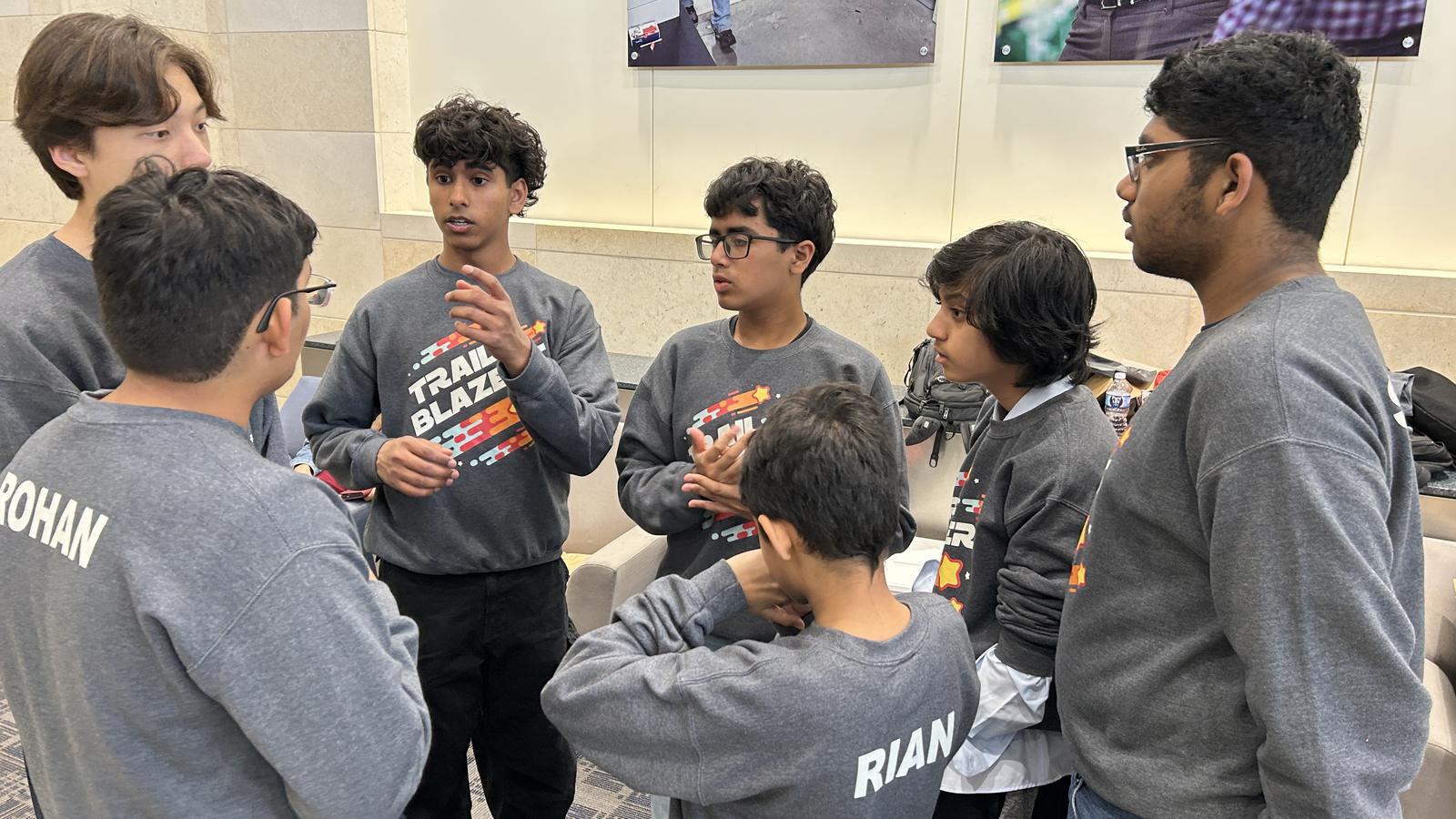 Trailblazers team huddle in matching sweatshirts